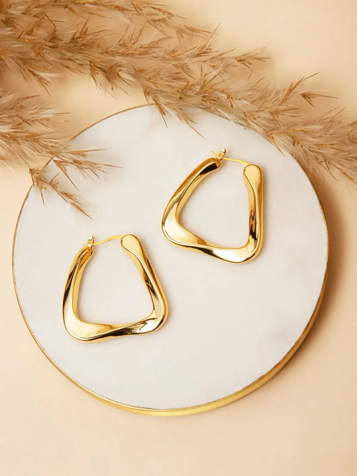Gold hoop earrings on textured surface